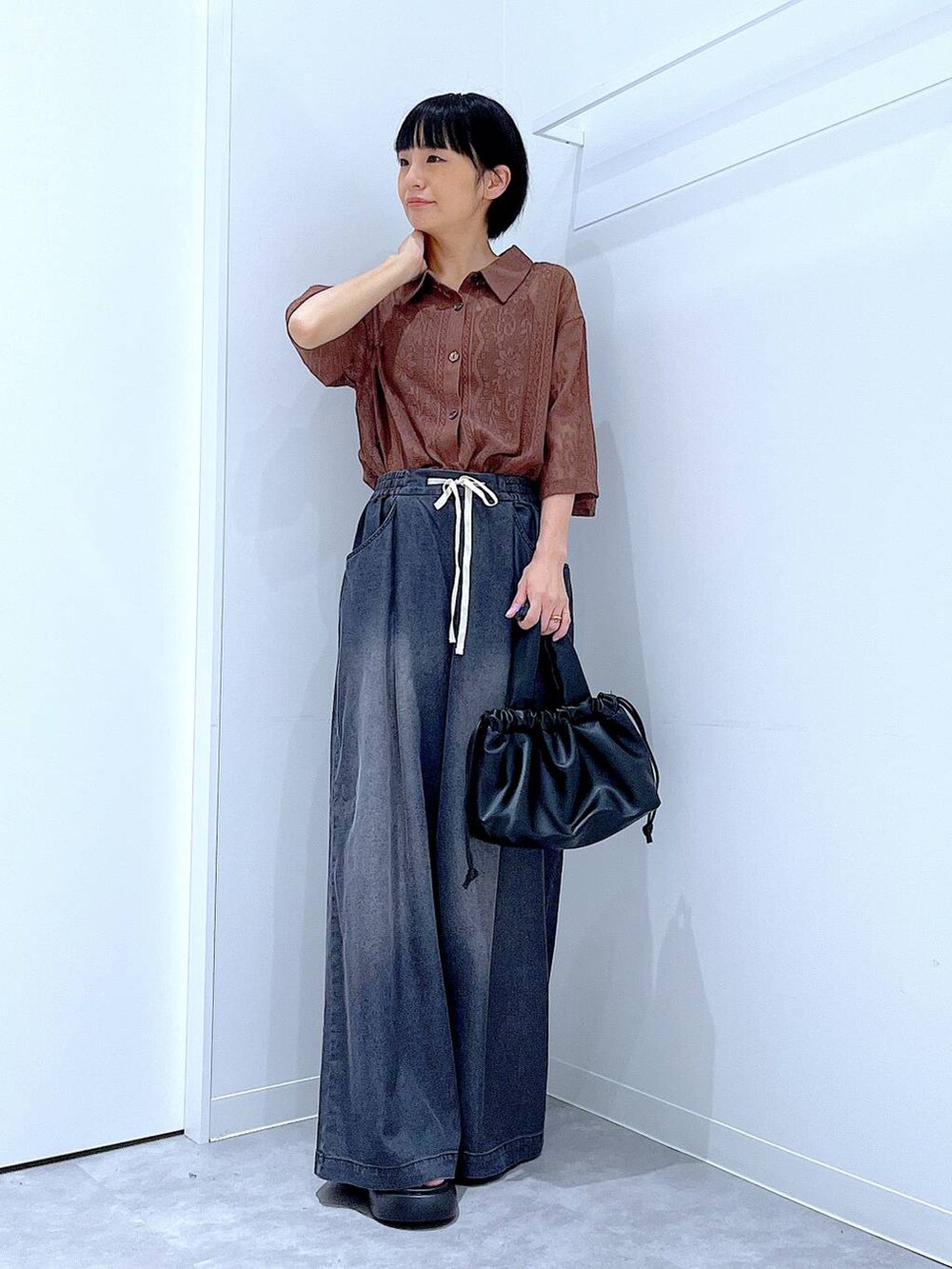 ブラウン系のシャツ/ブラウス、ブラック系のショルダーバッグ、ブラック系のデニムパンツを着用したレディースの夏コーディネートの2枚目の写真