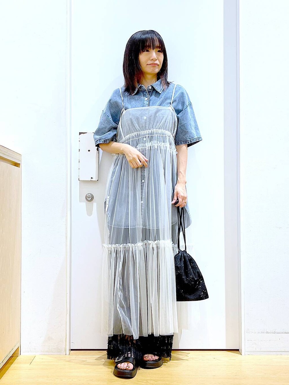 ホワイト系のワンピース、ブラック系のサンダル、ブラック系のその他パンツを着用したレディースの夏コーディネートの2枚目の写真