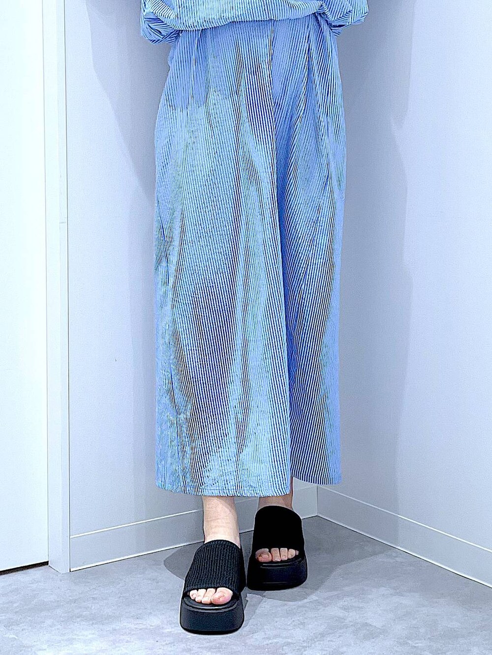 ブラック系のサンダル、ブルー系のワンピースを着用したレディースの夏コーディネートの8枚目の写真