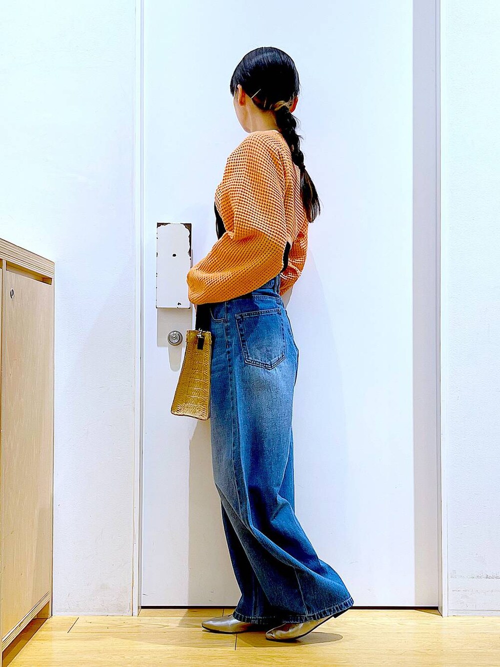 ブルー系のデニムパンツ、オレンジ系のカーディガン/ボレロ、その他のパンプスを着用したレディースの春コーディネートの3枚目の写真