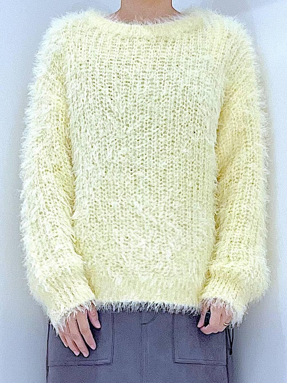 ブラック系のブーツ、イエロー系のニット/セーター、ブラック系のショルダーバッグを着用したレディースの冬コーディネートの7枚目の写真