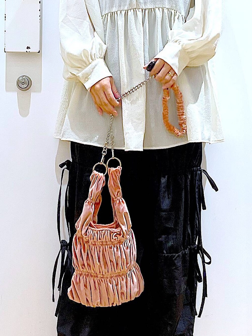 ホワイト系のパンプス、ブラック系のその他パンツ、ホワイト系のチュニックを着用したレディースの秋コーディネートの9枚目の写真