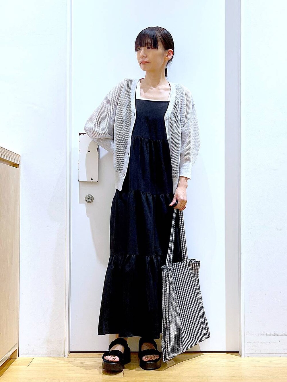 その他のトートバッグ、ブラック系のサンダル、ブラック系のワンピースを着用したレディースの夏コーディネートの2枚目の写真