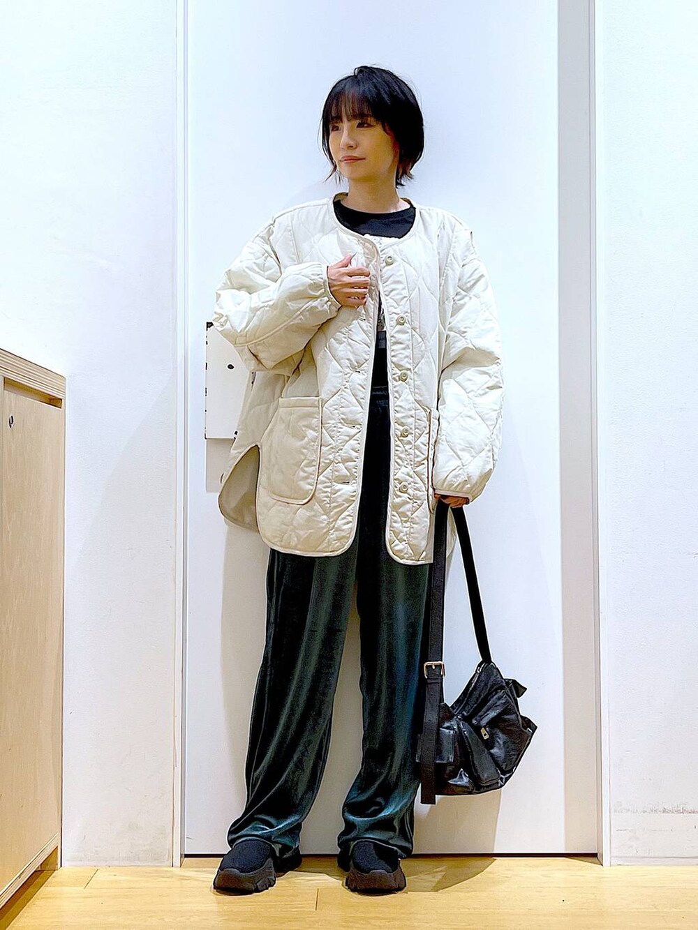 ベージュ系のブルゾン、ブラック系のTシャツ/カットソー、ブラック系のブーツを着用したレディースの冬コーディネートの2枚目の写真