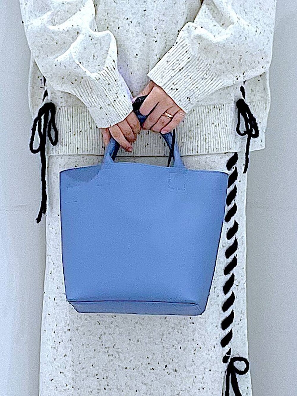 ブルー系のショルダーバッグ、ホワイト系のニット/セーター、ベージュ系のスカートを着用したレディースの秋コーディネートの9枚目の写真