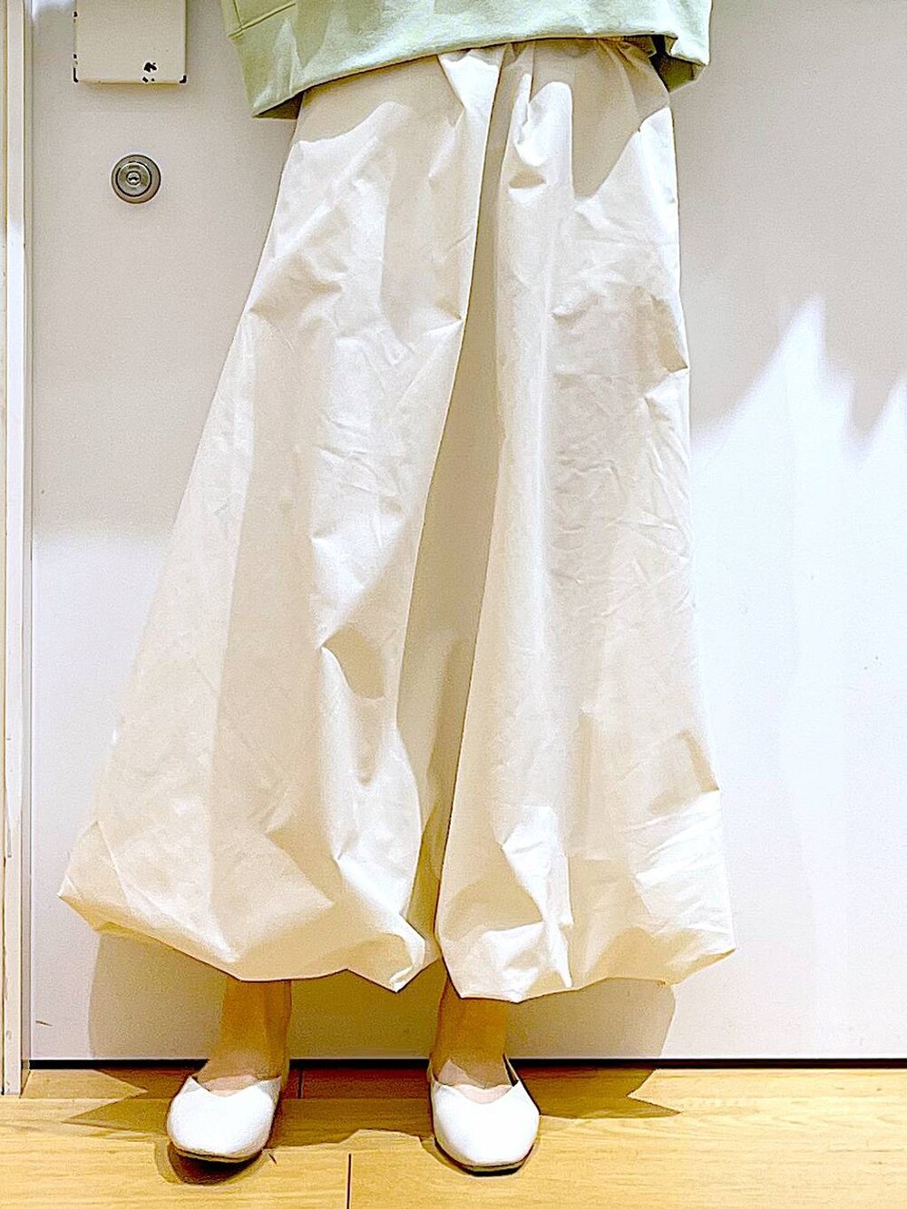 ホワイト系のパンプス、ベージュ系のショルダーバッグ、グリーン系のスウェットを着用したレディースの春コーディネートの8枚目の写真