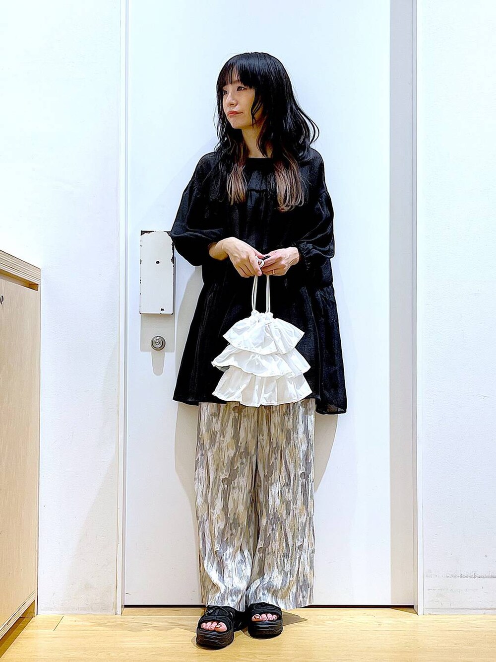 ホワイト系のショルダーバッグ、ブラック系のサンダル、ベージュ系のその他パンツを着用したレディースの夏コーディネートの2枚目の写真