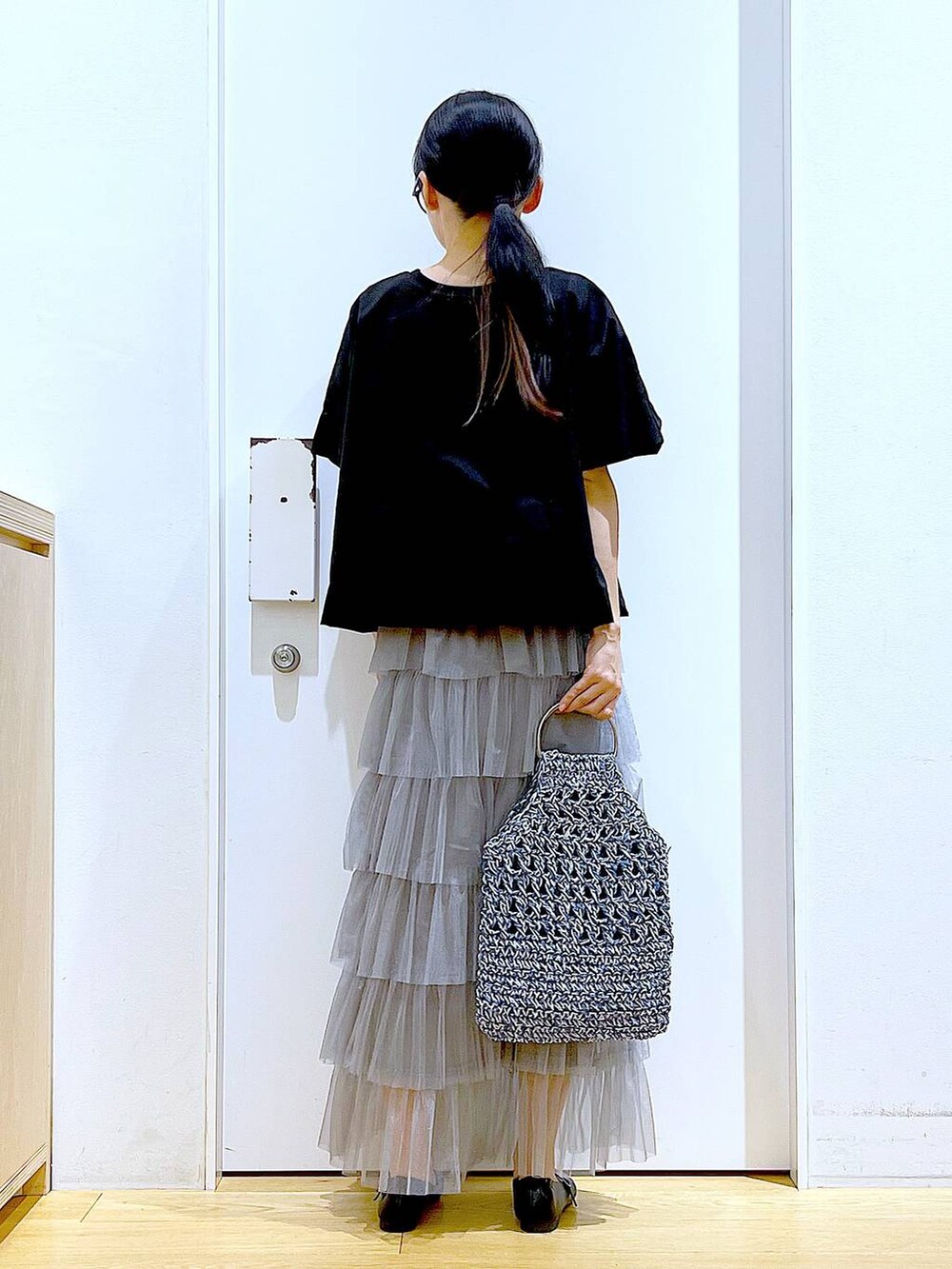 ブラック系のTシャツ/カットソー、ブラック系のパンプス、ブルー系のハンドバッグを着用したレディースの春コーディネートの5枚目の写真