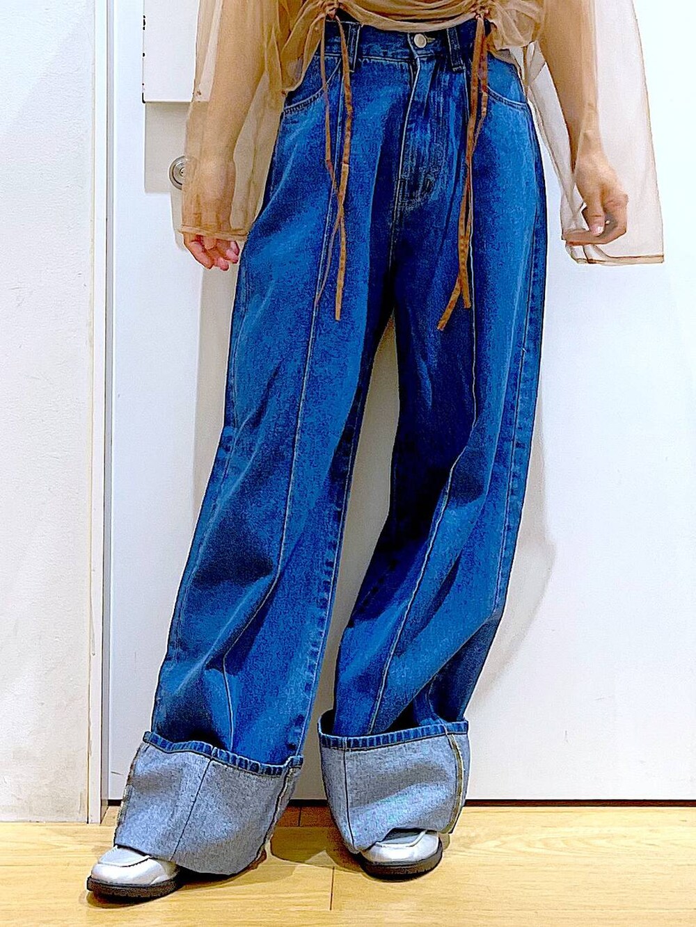 イエロー系のハンドバッグ、シルバー系のローファー、ブルー系のデニムパンツを着用したレディースの秋コーディネートの8枚目の写真