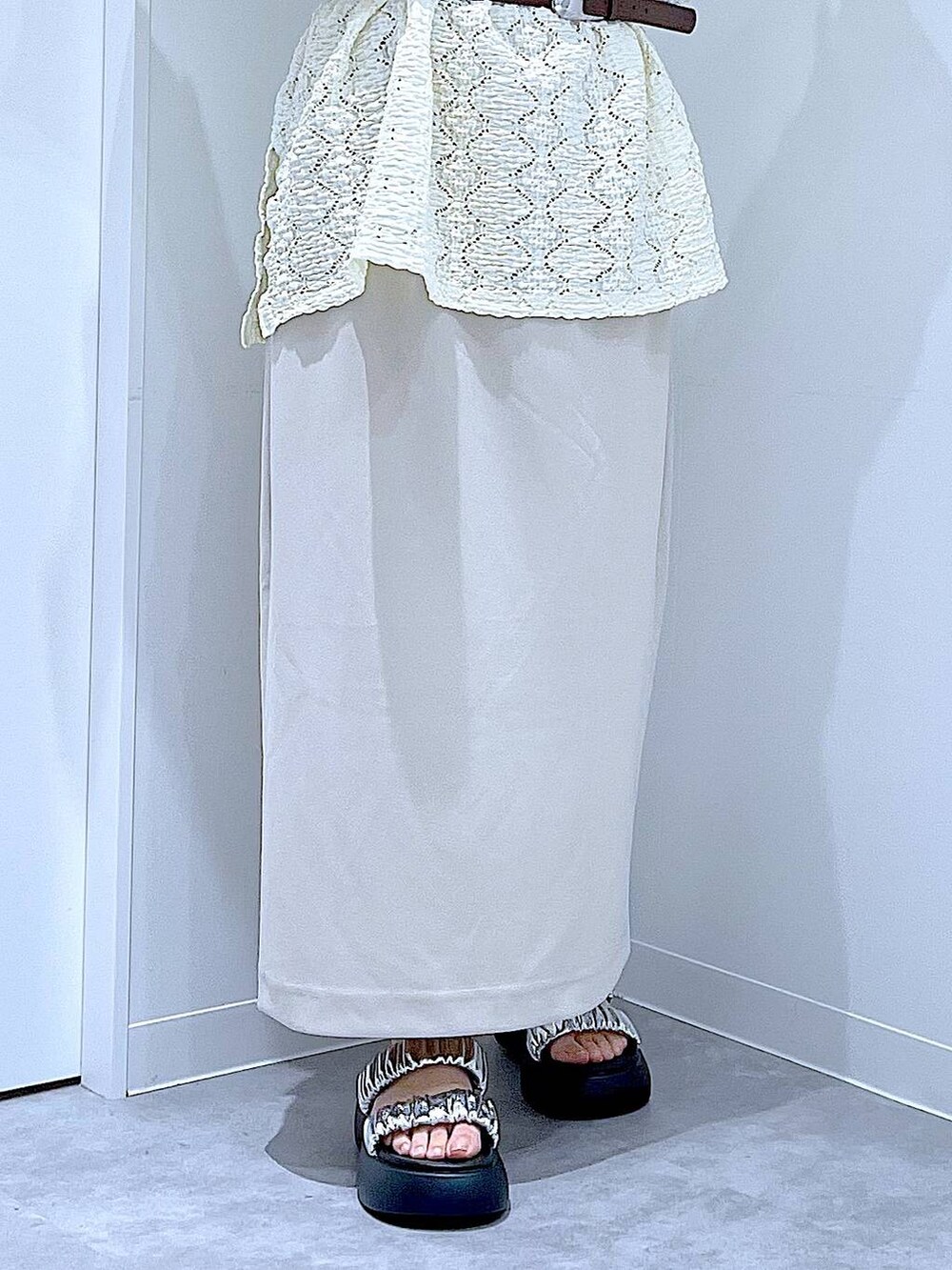 シルバー系のサンダル、ベージュ系のスカート、シルバー系のショルダーバッグを着用したレディースの夏コーディネートの8枚目の写真