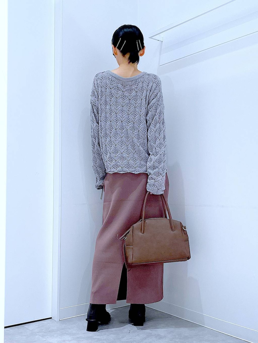 ブラウン系のボストンバッグ、ブラック系のブーツ、グレー系のカーディガン/ボレロを着用したレディースの冬コーディネートの5枚目の写真