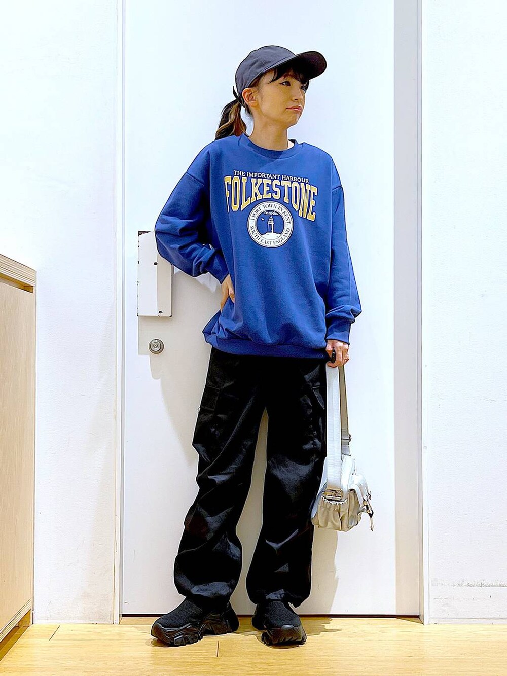 ブラック系のカーゴパンツ、ブラック系のスニーカー、ブルー系のスウェットを着用したレディースの冬コーディネートの2枚目の写真