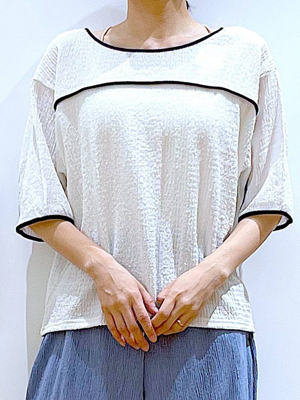 ブラック系のトートバッグ、ブラック系のサンダル、ホワイト系のTシャツ/カットソーを着用したレディースの夏コーディネートの7枚目の写真