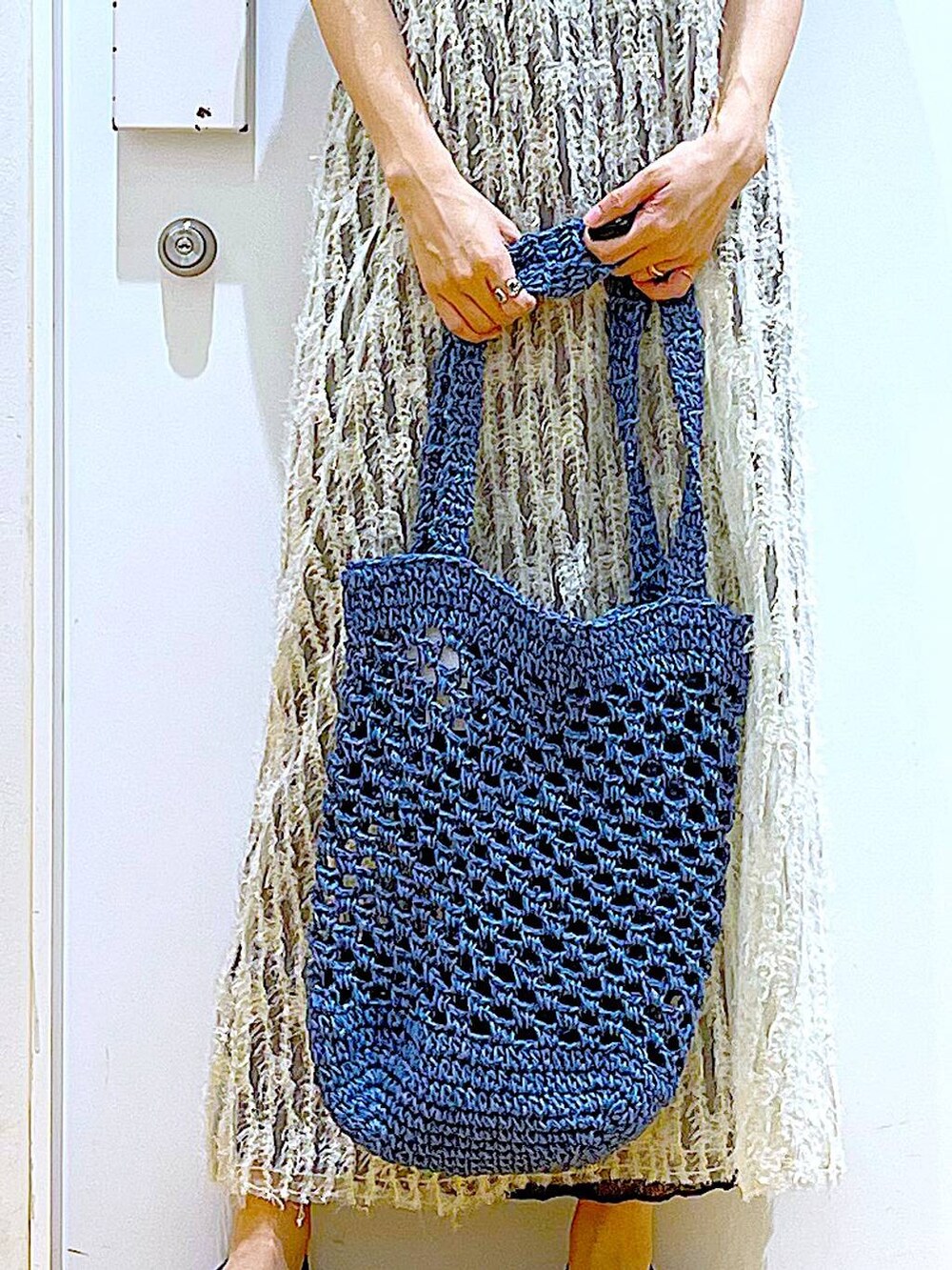 ベージュ系のワンピース、ブラック系のパンプス、ブルー系のトートバッグを着用したレディースの夏コーディネートの9枚目の写真