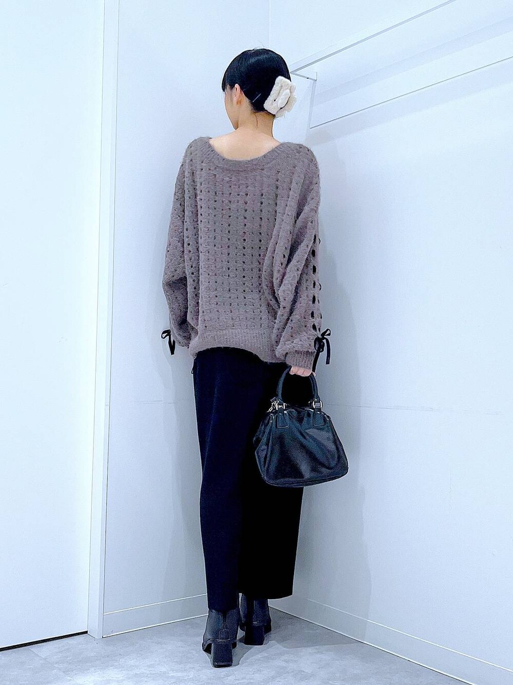 ブラック系のブーツ、ブラック系のショルダーバッグ、ベージュ系のニット/セーターを着用したレディースの冬コーディネートの5枚目の写真