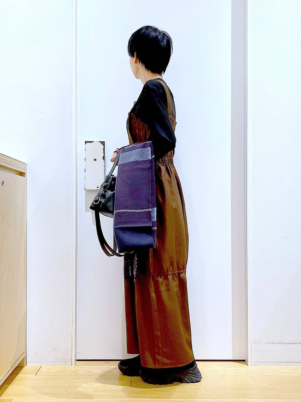 ブラック系のブーツ、ブラウン系のワンピース、ブラック系のショルダーバッグを着用したレディースの冬コーディネートの3枚目の写真