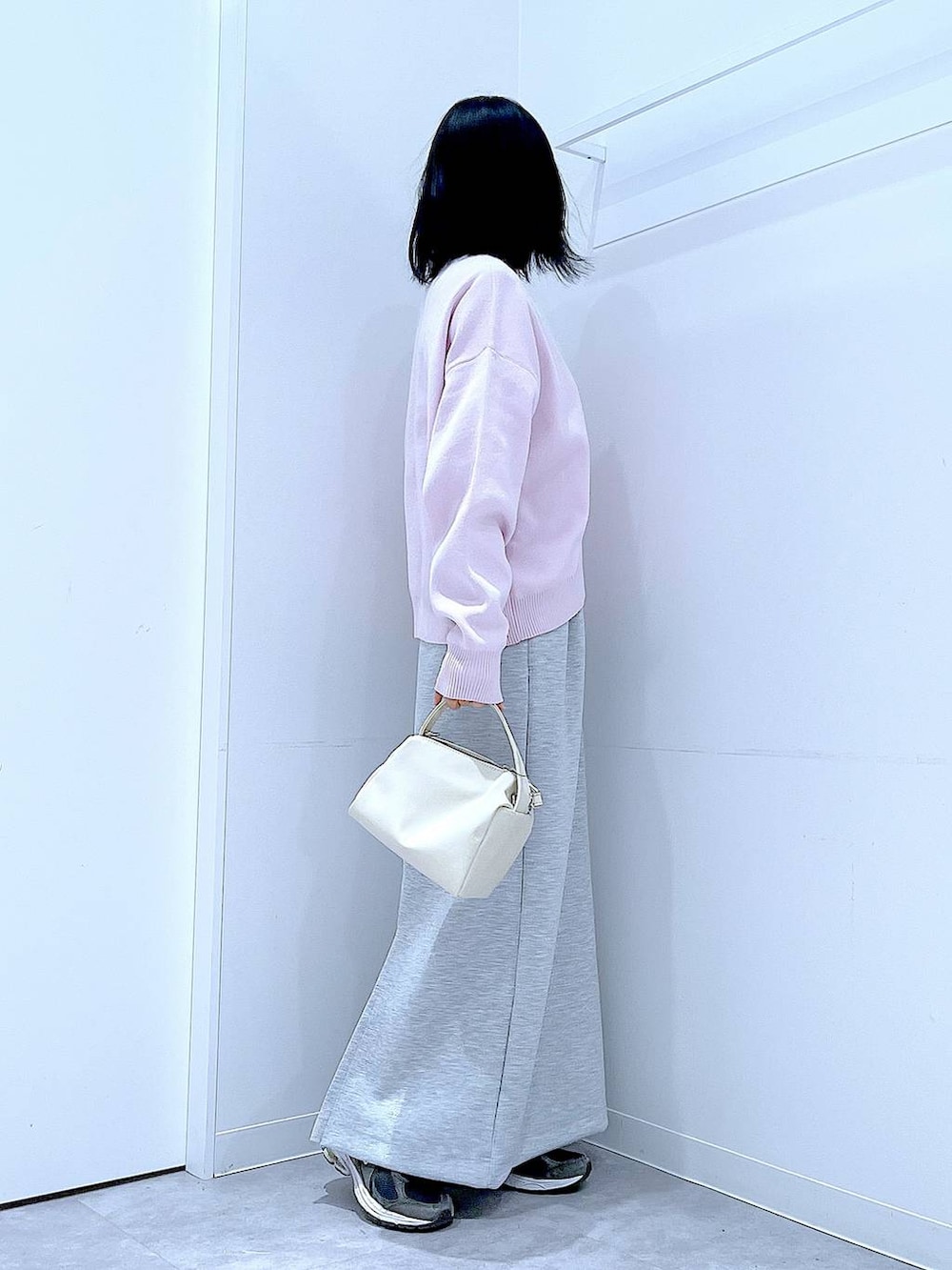 ホワイト系のショルダーバッグ、ピンク系のニット/セーター、グレー系のスカートを着用したレディースの冬コーディネートの4枚目の写真
