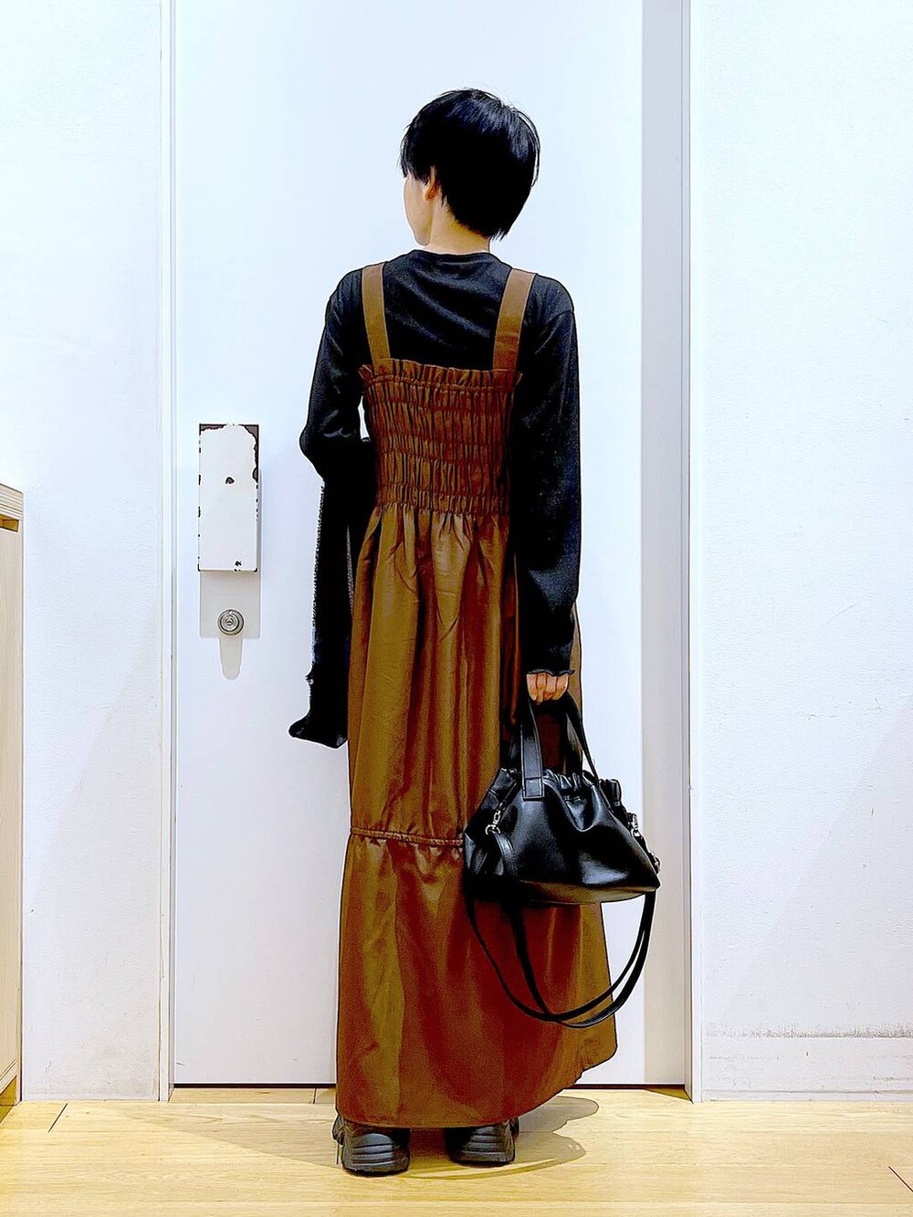 ブラック系のブーツ、ブラウン系のワンピース、ブラック系のショルダーバッグを着用したレディースの冬コーディネートの5枚目の写真