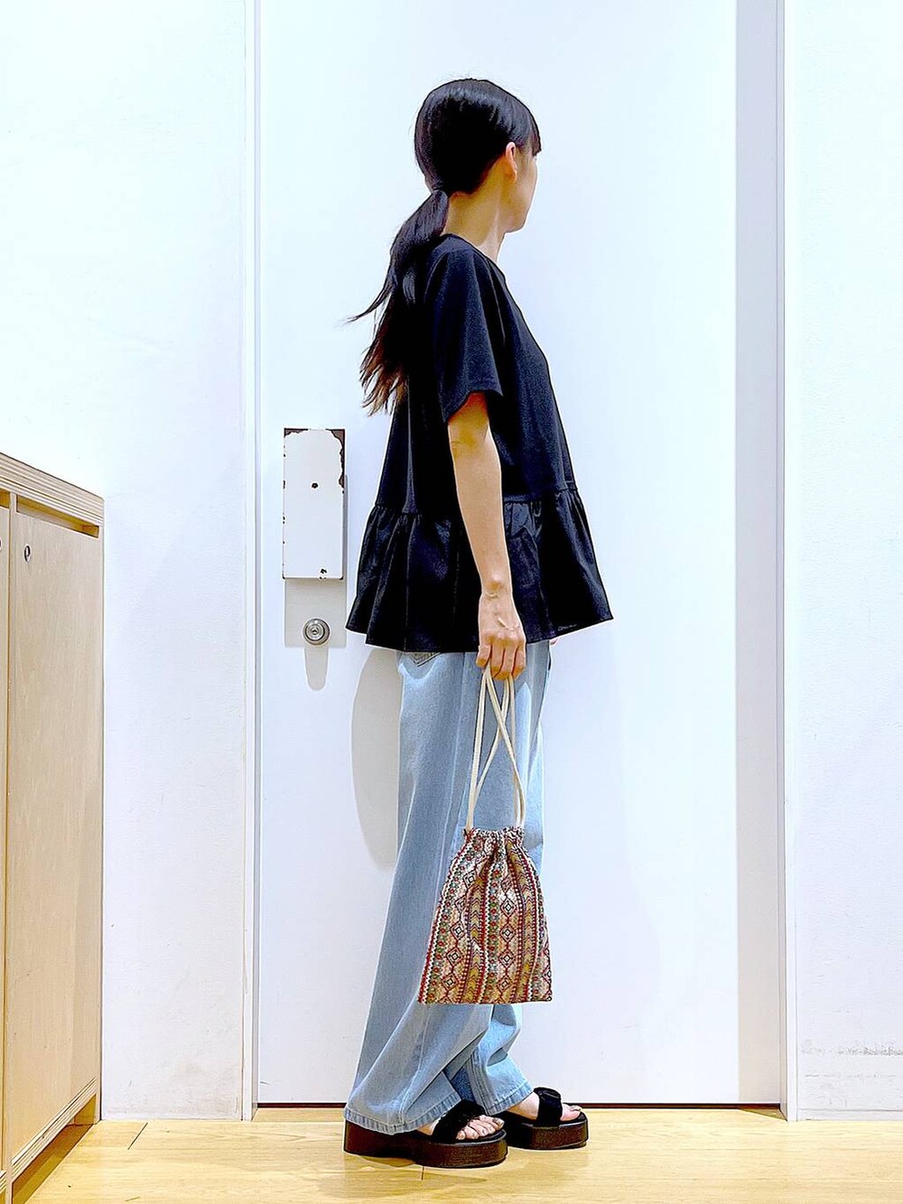 ピンク系のショルダーバッグ、ブルー系のデニムパンツ、ブラック系のTシャツ/カットソーを着用したレディースの夏コーディネートの4枚目の写真