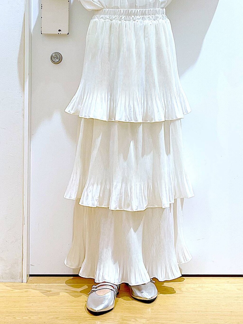 ベージュ系のスカート、シルバー系のパンプス、ホワイト系のシャツ/ブラウスを着用したレディースの秋コーディネートの8枚目の写真