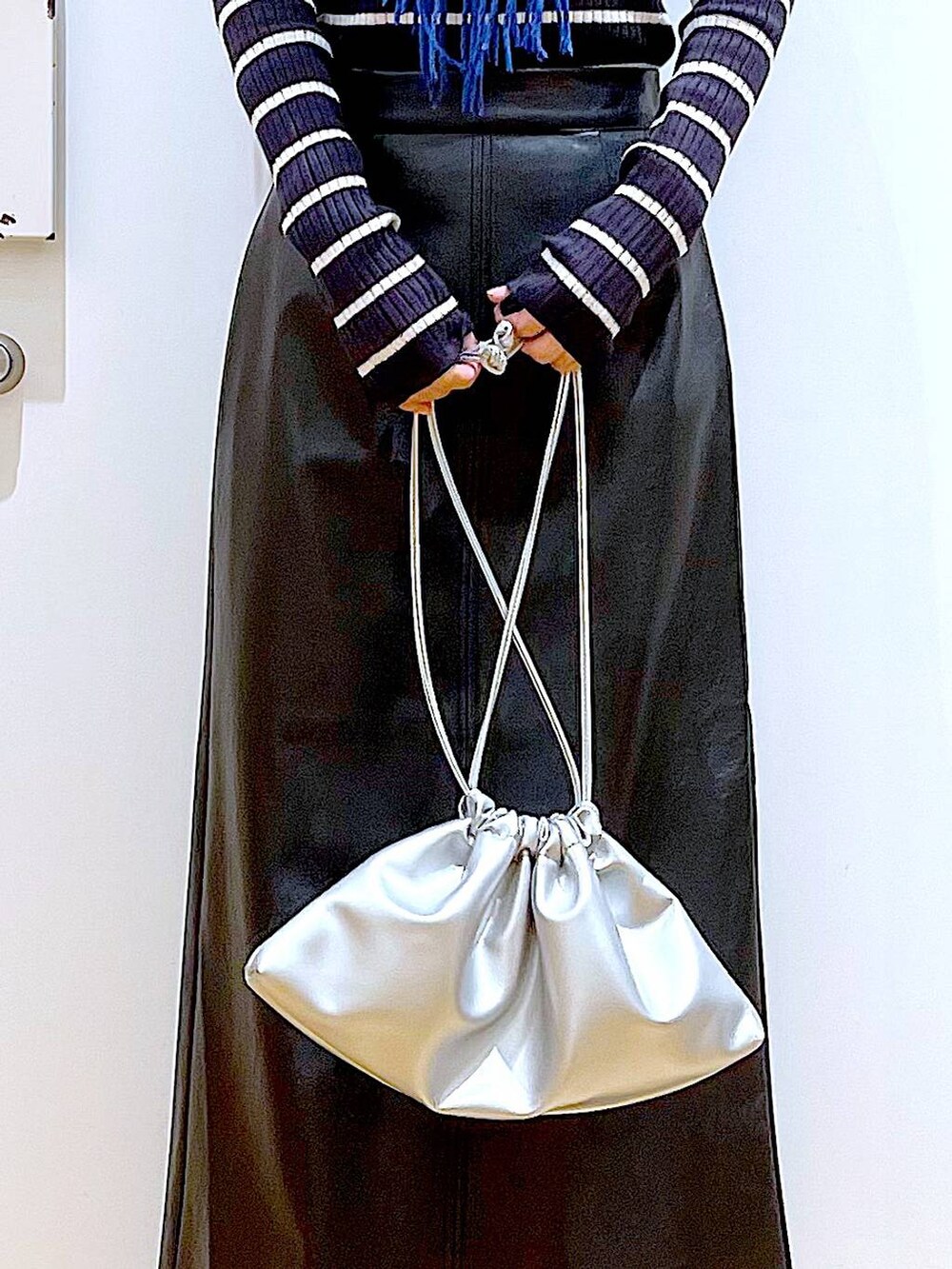 ブラック系のブーツ、ブルー系のニット/セーター、シルバー系のショルダーバッグを着用したレディースの冬コーディネートの9枚目の写真