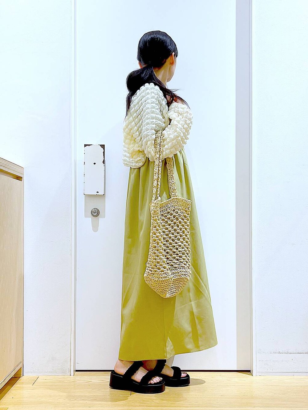 ブラック系のサンダル、ホワイト系のトートバッグ、ベージュ系のカーディガン/ボレロを着用したレディースの夏コーディネートの4枚目の写真