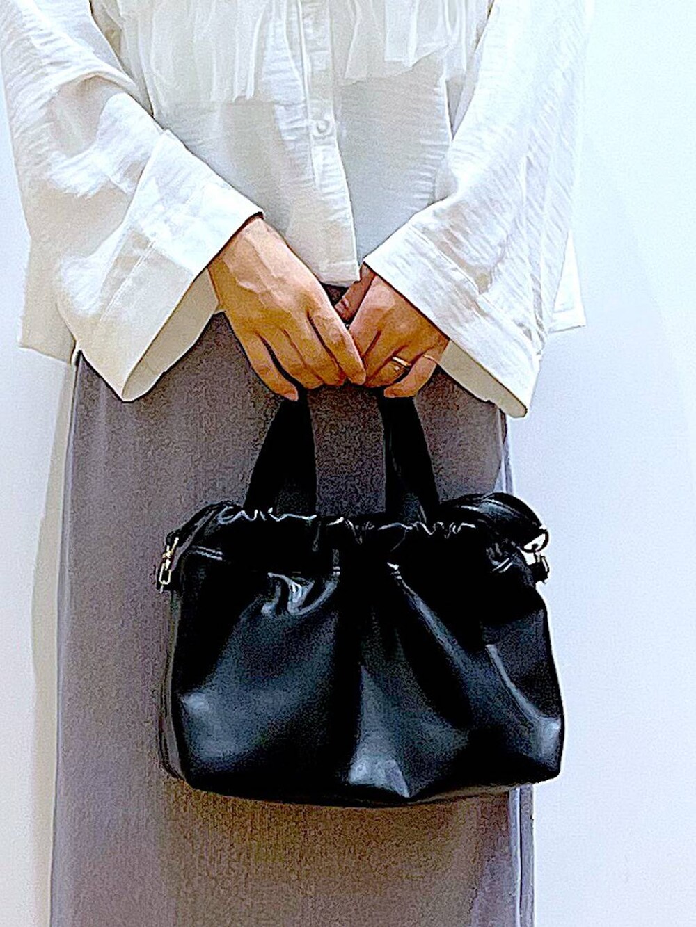 パープル系のスカート、ブラック系のショルダーバッグ、ブラック系のパンプスを着用したレディースの秋コーディネートの9枚目の写真