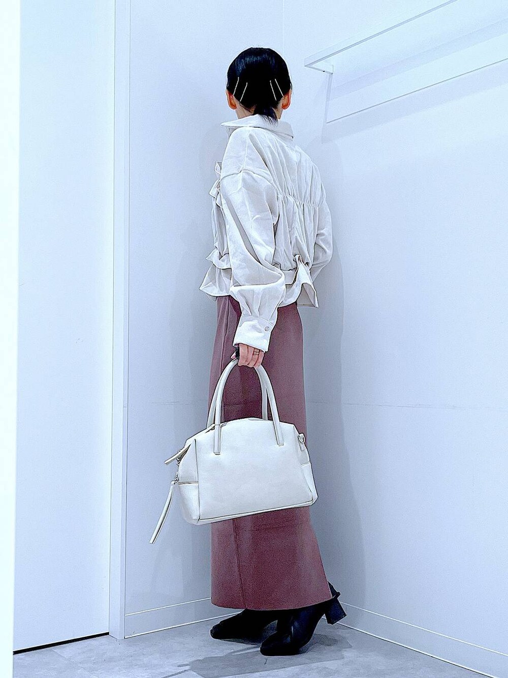 グレー系のボストンバッグ、ブラック系のブーツ、ベージュ系のシャツ/ブラウスを着用したレディースの秋コーディネートの3枚目の写真