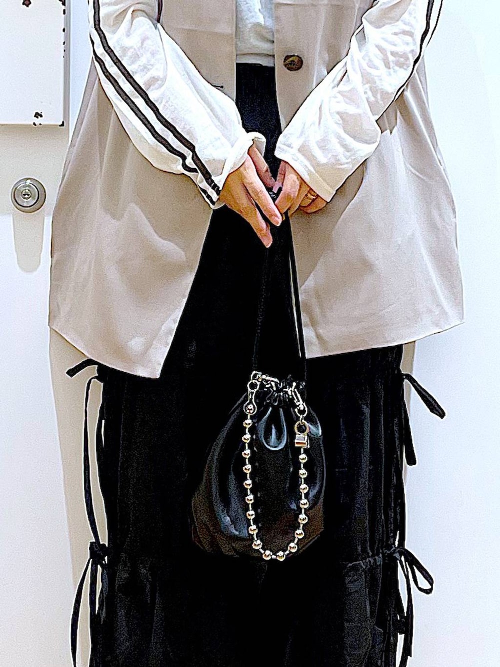 ブラック系のショルダーバッグ、ホワイト系のパンプス、ブラック系のその他パンツを着用したレディースの秋コーディネートの9枚目の写真