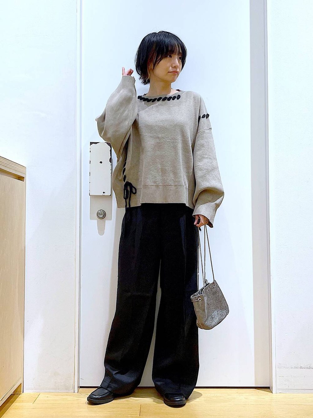 グレー系のショルダーバッグ、ブラック系のローファー、ブラウン系のニット/セーターを着用したレディースの冬コーディネートの2枚目の写真