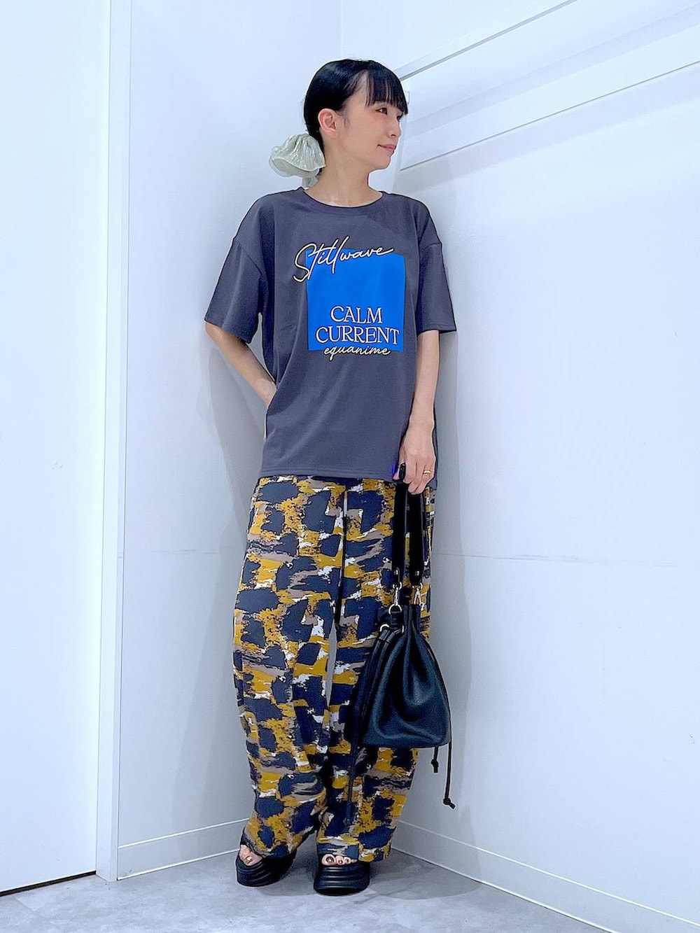 グレー系のTシャツ/カットソー、グレー系のその他パンツ、ブラック系のサンダルを着用したレディースの夏コーディネートの2枚目の写真