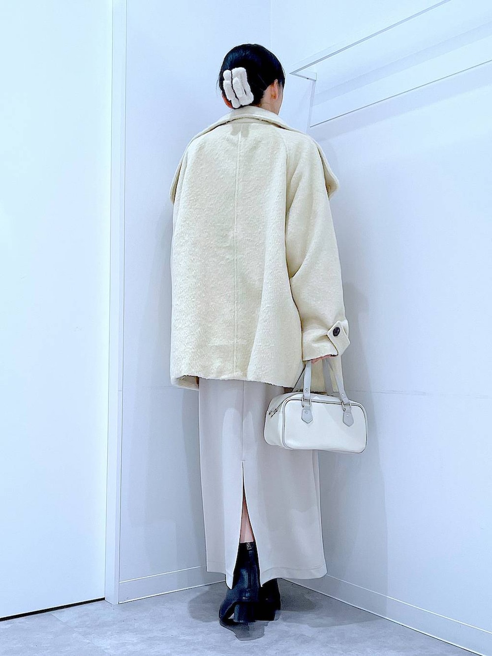 ベージュ系のスカート、ベージュ系のステンカラーコート、ブラック系のブーツを着用したレディースの冬コーディネートの5枚目の写真