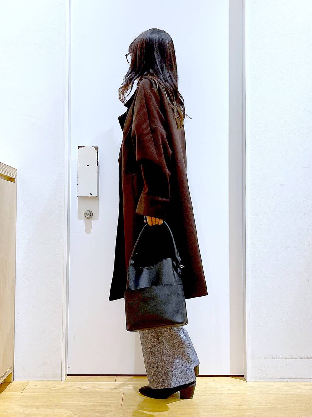 ブラウン系のステンカラーコート、ブラック系のショルダーバッグ、その他のニット/セーターを着用したレディースの冬コーディネートの3枚目の写真