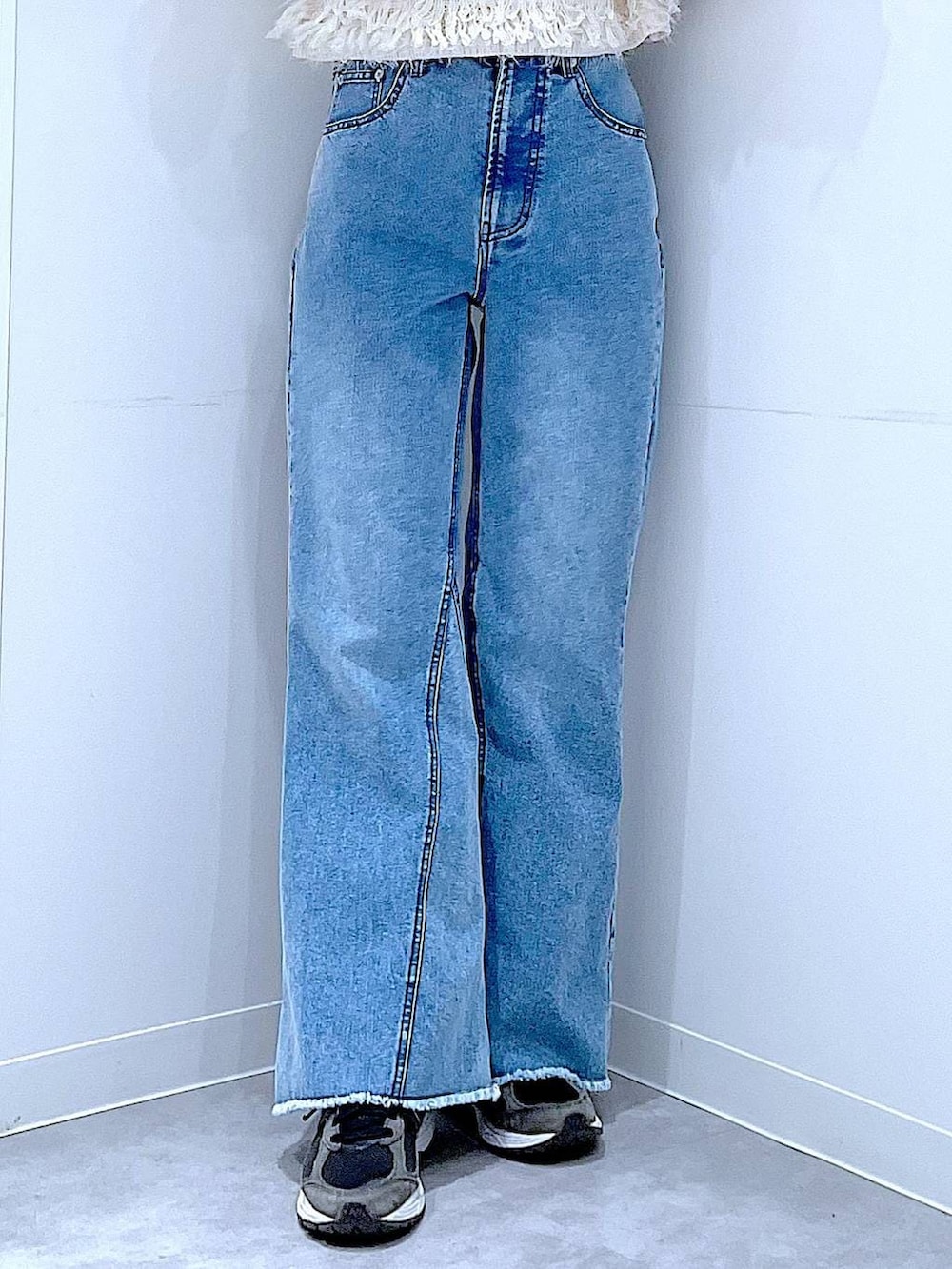 ホワイト系のベスト、グレー系のニット/セーター、ブルー系のデニムパンツを着用したレディースの春コーディネートの8枚目の写真