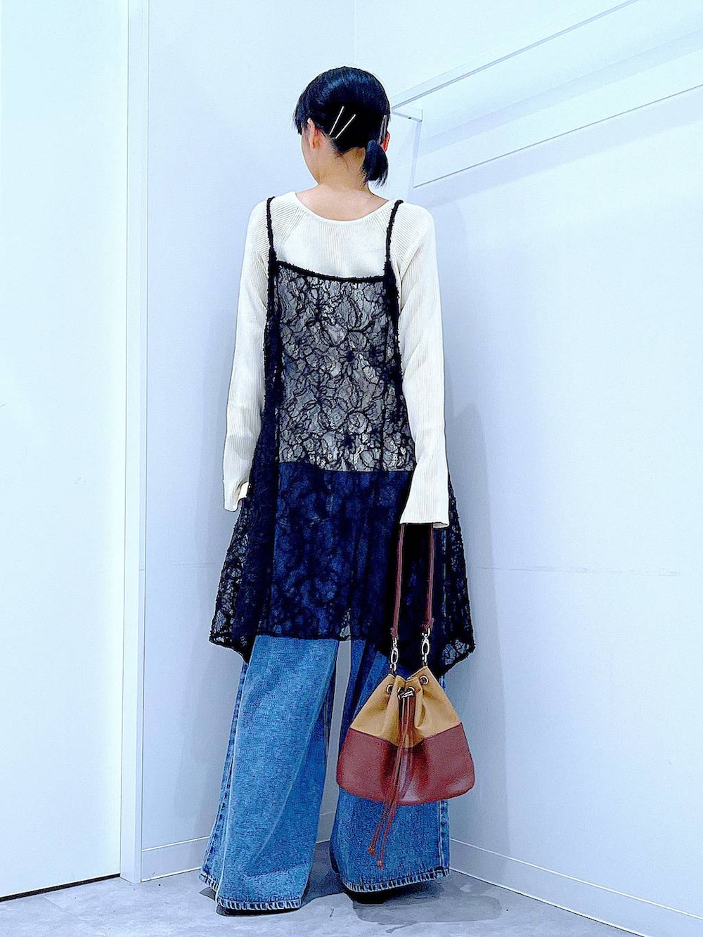 ベージュ系のニット/セーター、ブルー系のデニムパンツ、ベージュ系のショルダーバッグを着用したレディースの秋コーディネートの5枚目の写真