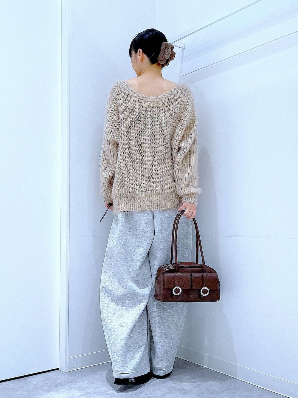 ブラウン系のショルダーバッグ、ブラック系のブーツ、グレー系のスウェットパンツを着用したレディースの冬コーディネートの5枚目の写真