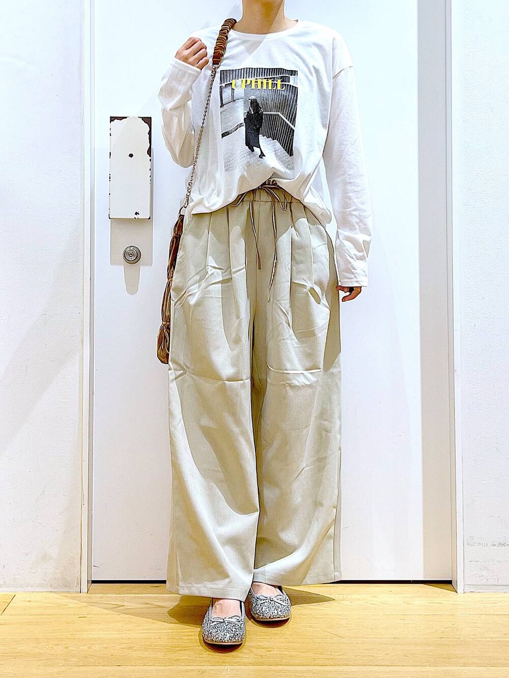 シルバー系のパンプス、イエロー系のショルダーバッグ、ベージュ系のその他パンツを着用したレディースの秋コーディネートの6枚目の写真