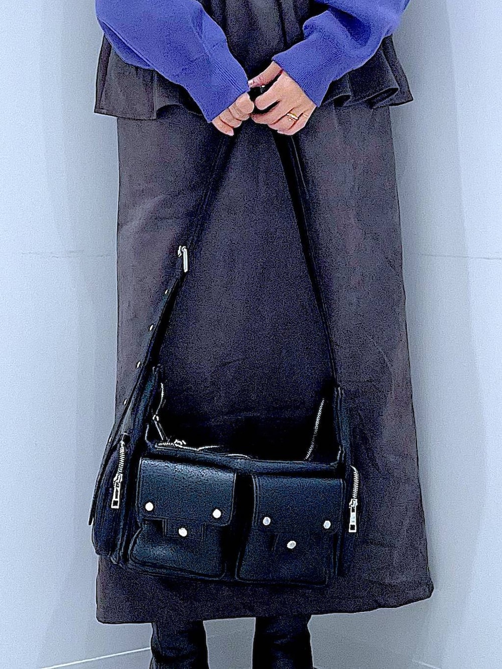 ブラック系のショルダーバッグ、ブルー系のニット/セーター、ブラック系のブーツを着用したレディースの秋コーディネートの9枚目の写真