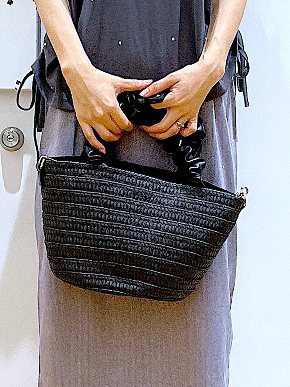 パープル系のスカート、ブラック系のショルダーバッグ、ブラック系のサンダルを着用したレディースの夏コーディネートの9枚目の写真