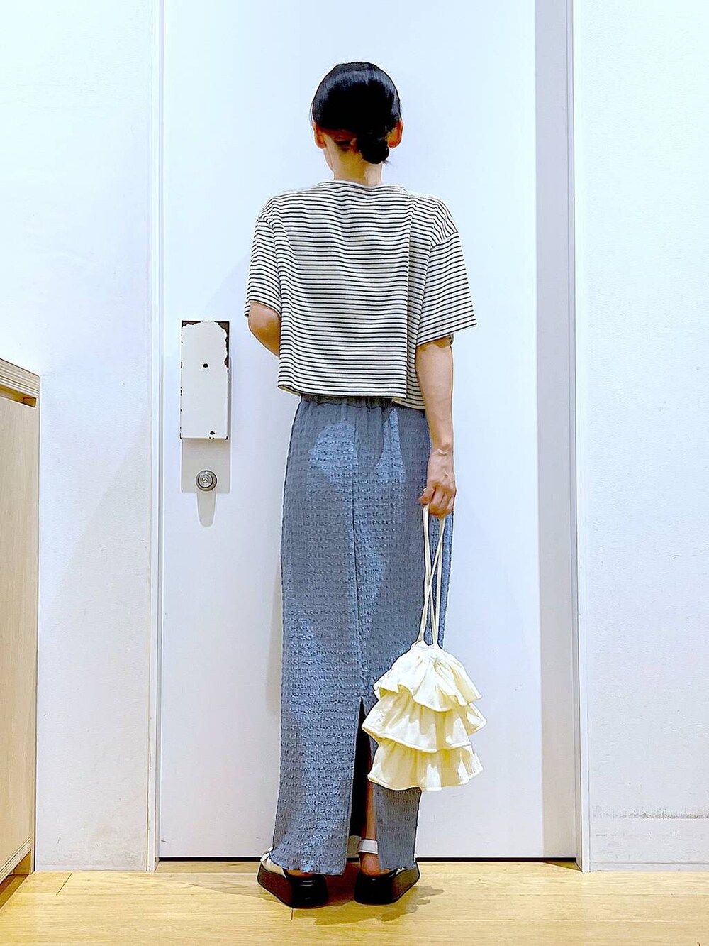 ホワイト系のサンダル、ブルー系のスカート、ホワイト系のショルダーバッグを着用したレディースの秋コーディネートの5枚目の写真