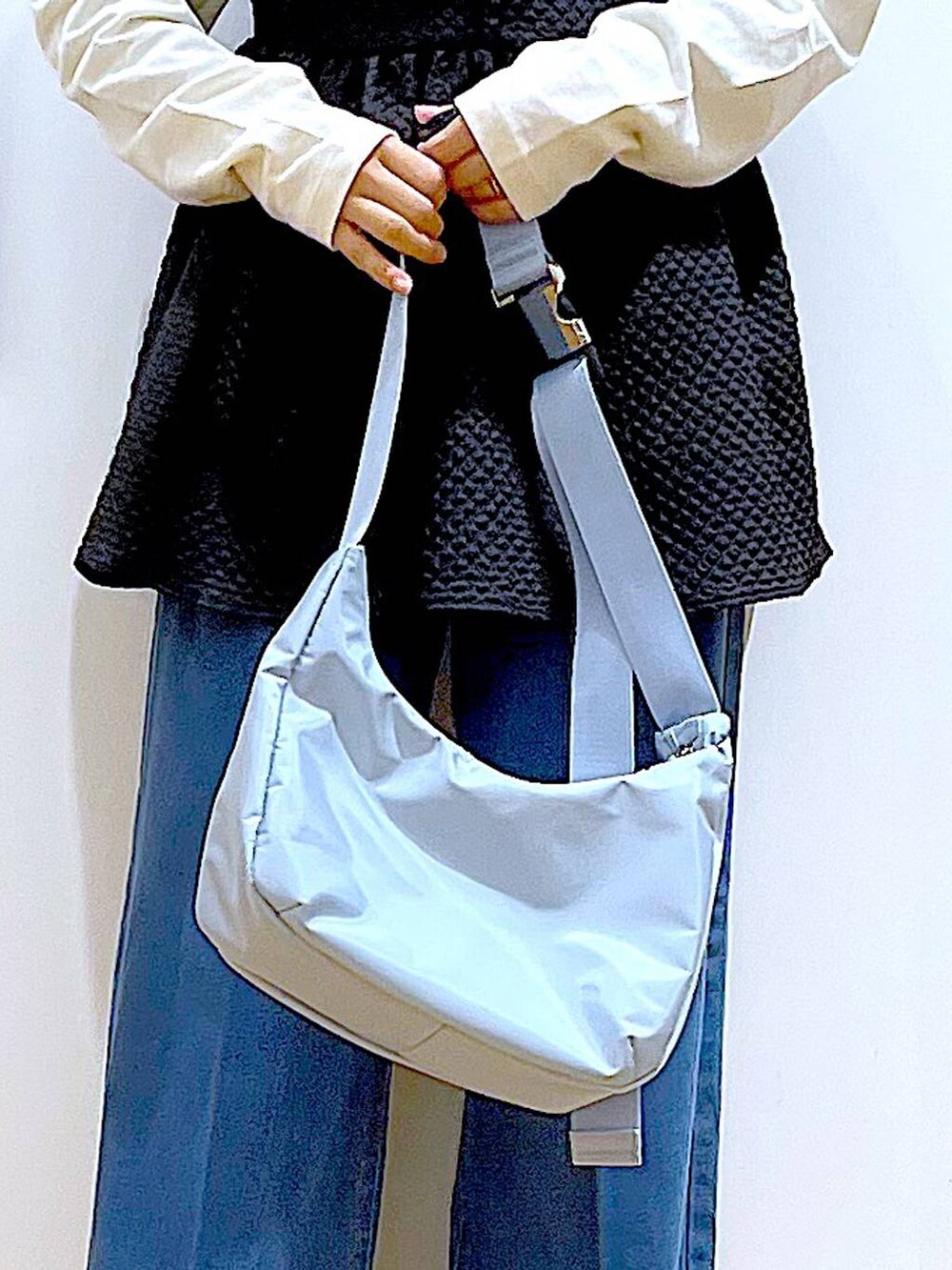 ブルー系のデニムパンツ、ホワイト系のTシャツ/カットソー、ブルー系のショルダーバッグを着用したレディースの春コーディネートの9枚目の写真