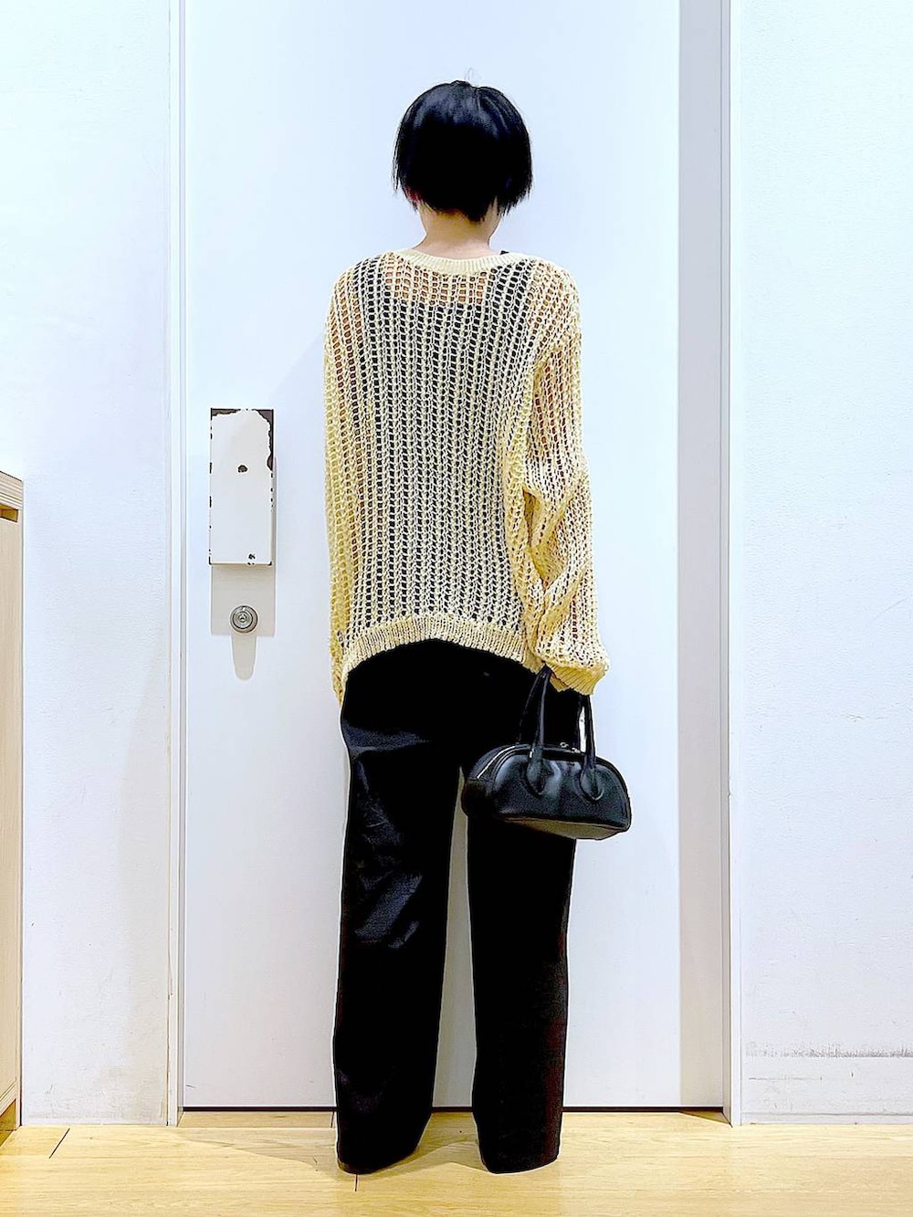 ブラック系のスラックス、ブラック系のボストンバッグ、ブラック系のパンプスを着用したレディースの夏コーディネートの5枚目の写真