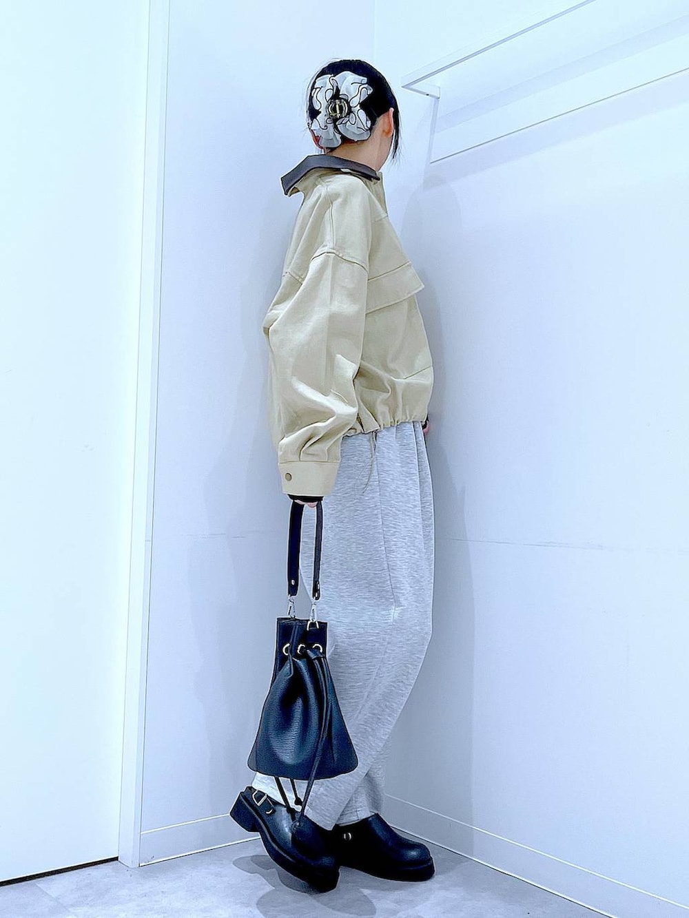 ブラック系のサンダル、ブラック系のショルダーバッグ、ベージュ系のブルゾンを着用したレディースの春コーディネートの4枚目の写真