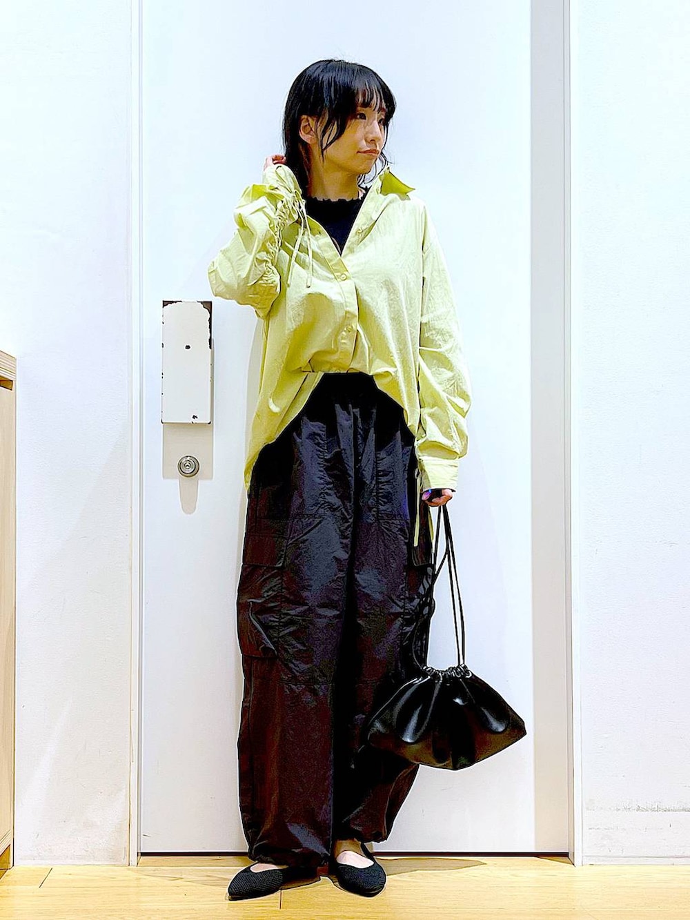 グリーン系のシャツ/ブラウス、ブラック系のショルダーバッグ、ブラック系のパンプスを着用したレディースの春コーディネートの2枚目の写真