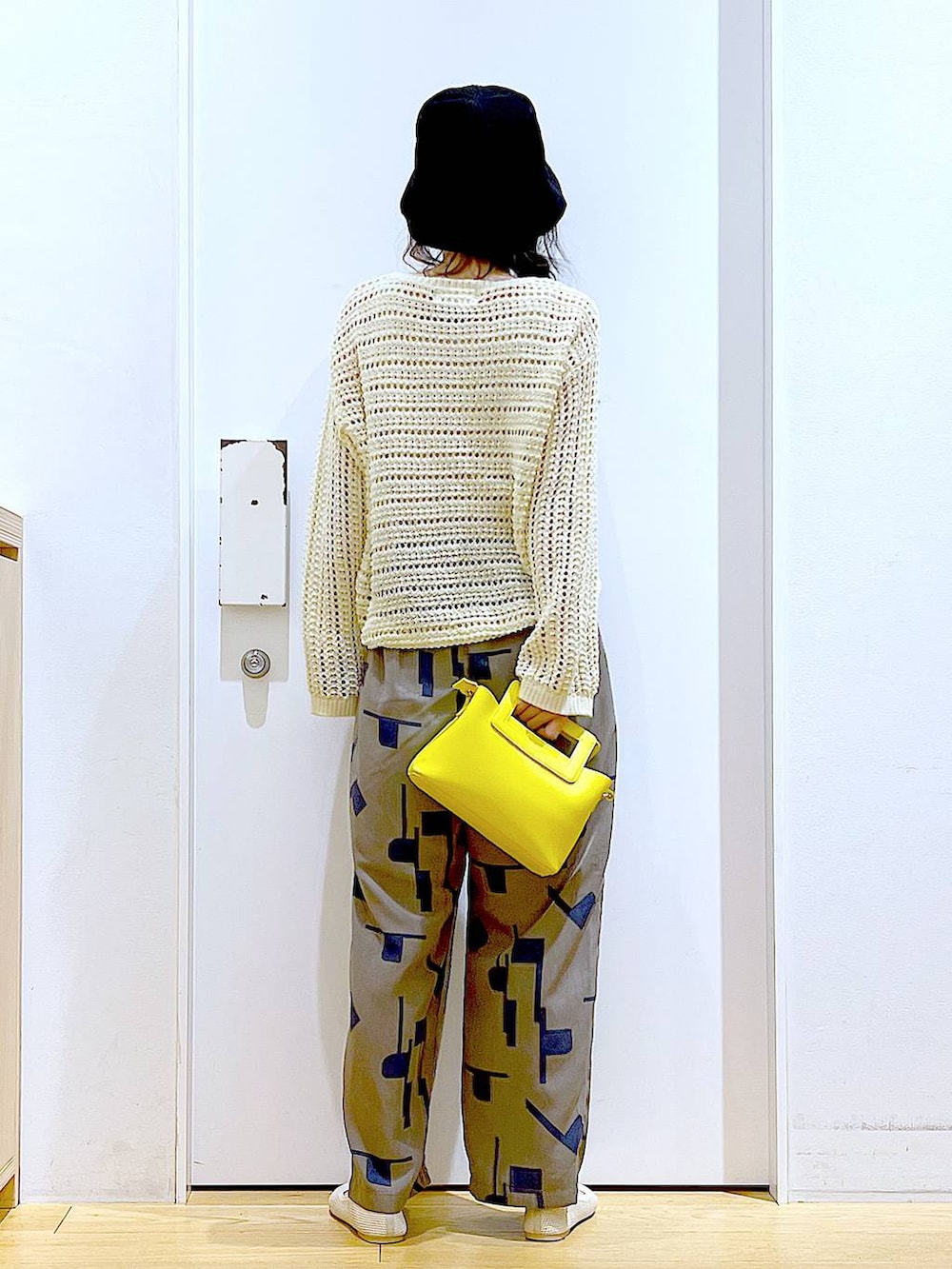 ホワイト系のニット/セーター、イエロー系のショルダーバッグ、ホワイト系のパンプスを着用したレディースの春コーディネートの5枚目の写真