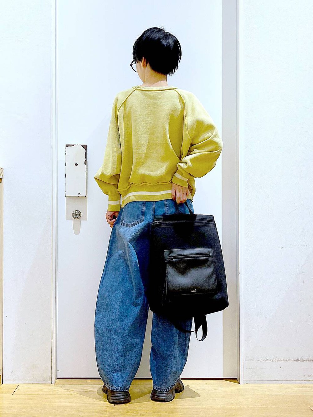 ブルー系のデニムパンツ、ブラック系のバックパック/リュック、ブラック系のブーツを着用したレディースの冬コーディネートの5枚目の写真