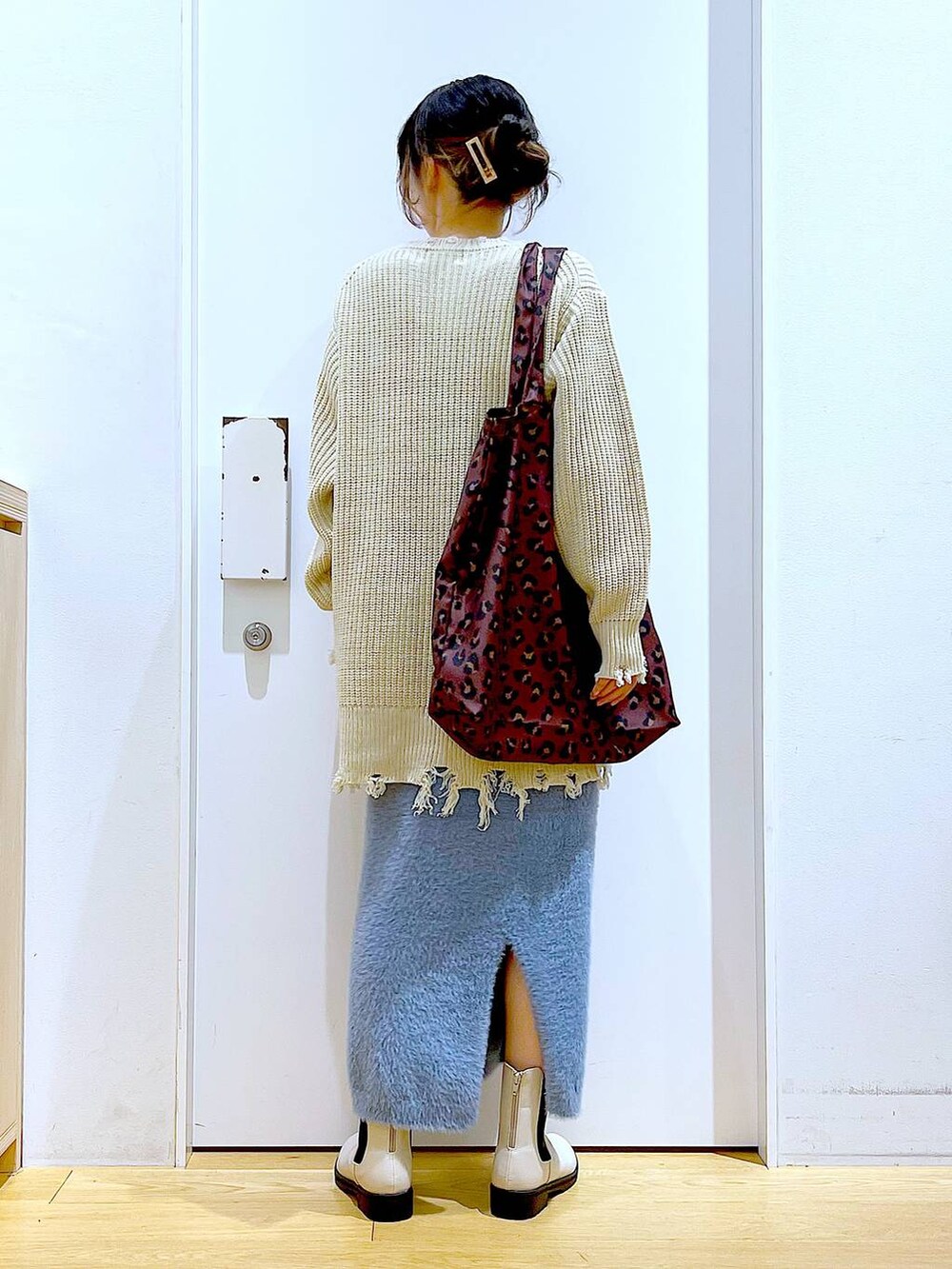 ベージュ系のブーツ、その他のトートバッグ、ブルー系のスカートを着用したレディースの冬コーディネートの5枚目の写真