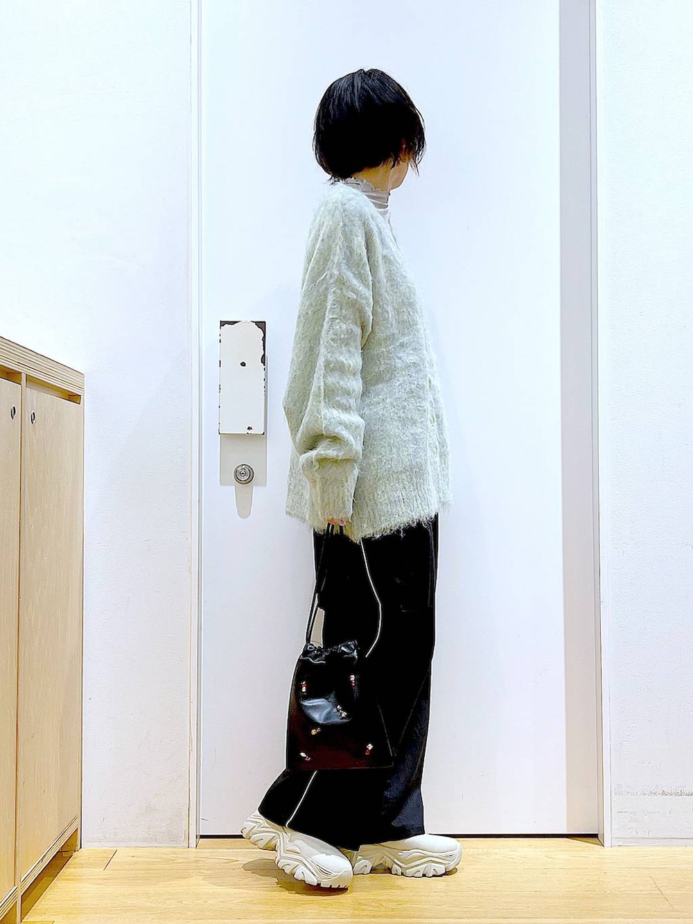 グリーン系のカーディガン/ボレロ、ブラック系のスラックス、ブラック系のショルダーバッグを着用したレディースの冬コーディネートの4枚目の写真