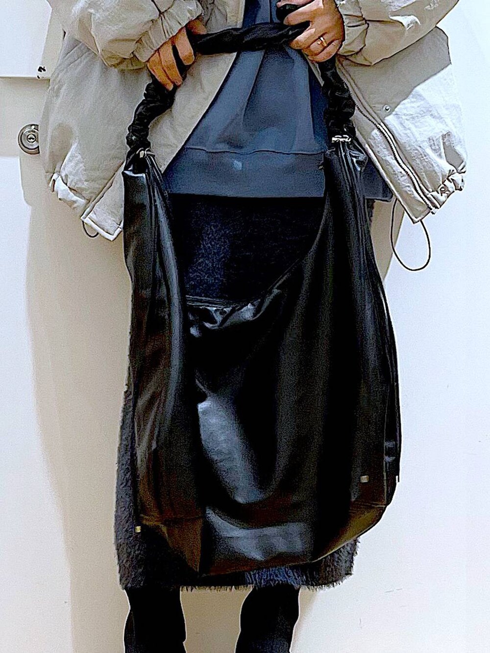 ブラック系のブーツ、ブルー系のスウェット、ブラック系のショルダーバッグを着用したレディースの冬コーディネートの9枚目の写真