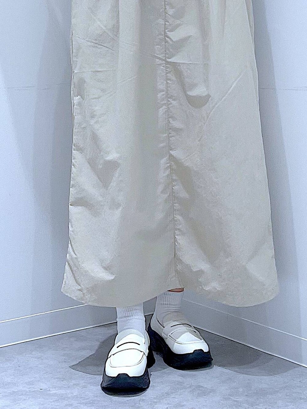 ホワイト系のローファー、ホワイト系のショルダーバッグ、グレー系のワンピースを着用したレディースの秋コーディネートの8枚目の写真